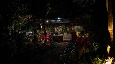 a dark garden at night with a table and plants at Trisara Boutique Stay in Mysore
