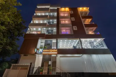 a tall building with many windows at night at Treebo Adithi Comforts Inn And Suites in Mysore