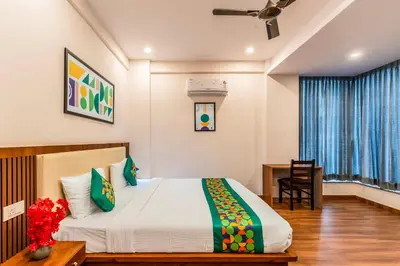 a bedroom with a bed and a desk and a window at Treebo Adithi Comforts Inn And Suites in Mysore