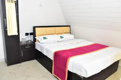 a bedroom with a bed with a colorful blanket on it at Cloudy Nandy Hills Poombarai in Kūkkāl
