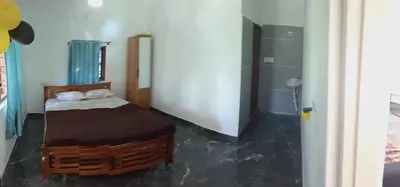 a bathroom with a bed and a shower in a room at JK Cottages in Suntikoppa