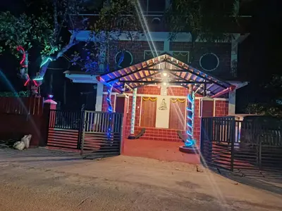 a gingerbread house is lit up at night at JK Cottages in Suntikoppa