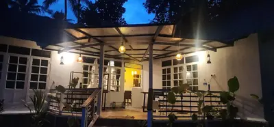 a pergola on a patio at night at Kodamukku cottage in Trichūr