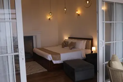a bedroom with a bed and a room with a fireplace at Memories at The Blue Mountains in Kotagiri
