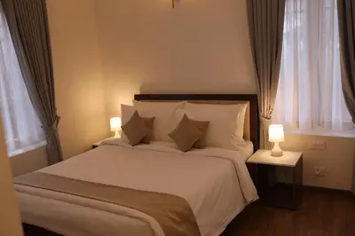 a bedroom with a large bed with two lamps at Memories at The Blue Mountains in Kotagiri