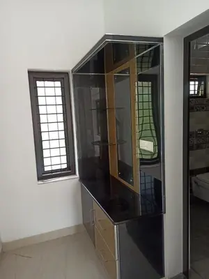 a room with a glass cabinet and two windows at Liyano homestay in Palakkad