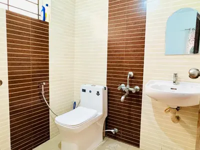 a bathroom with a toilet and a sink at Anandha Vibes in Guruvāyūr