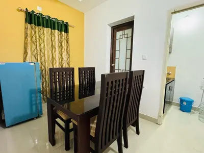 a dining room with a glass table and two chairs at Anandha Vibes in Guruvāyūr