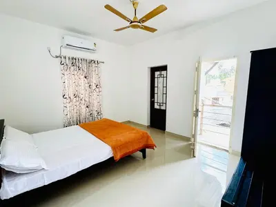 a bedroom with a bed and a ceiling fan at Anandha Vibes in Guruvāyūr