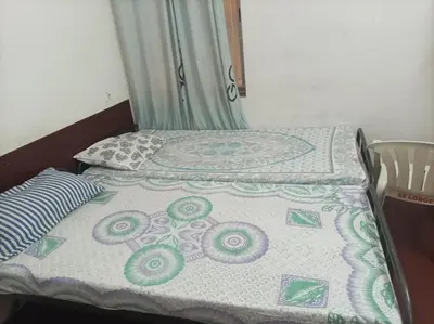 a bed with a quilt on it in a room at chenniyappa lodge in Chennimalai