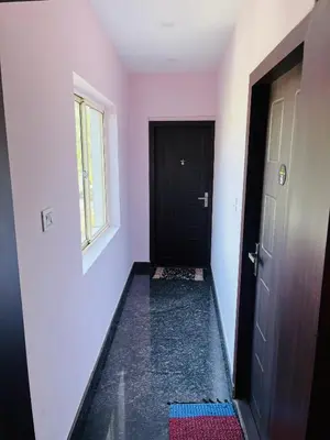 a hallway with a black door and a window at Homey - vythiri bus station in Vythiri