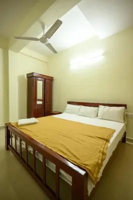 a large bed in a room with a ceiling fan at Skybz Resort - Mankulam in Viripara