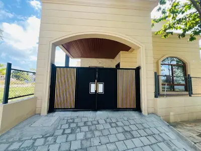 a black and yellow garage door with an archway at Green Heaven Mysore Homestay in Mysore
