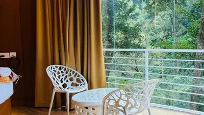 two chairs and a table in front of a window at Zeno Village Resort 900 Kandi Wayanad in Wayanad