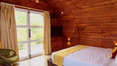 a bedroom with a bed and a large window at Zeno Village Resort 900 Kandi Wayanad in Wayanad