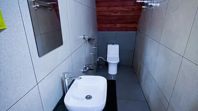 a small bathroom with a sink and a toilet at Zeno Village Resort 900 Kandi Wayanad in Wayanad