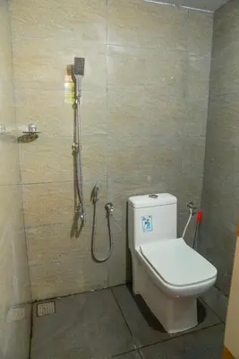 a bathroom with a toilet and a shower at Orange Villa -3 AC Rooms Near Airport in Ernakulam