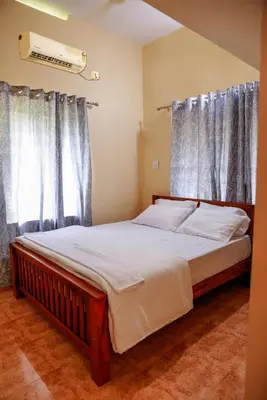 a bedroom with a large bed with curtains at Orange Villa -3 AC Rooms Near Airport in Ernakulam