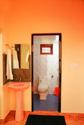 a bathroom with a toilet and a sink at Orange Villa -3 AC Rooms Near Airport in Ernakulam