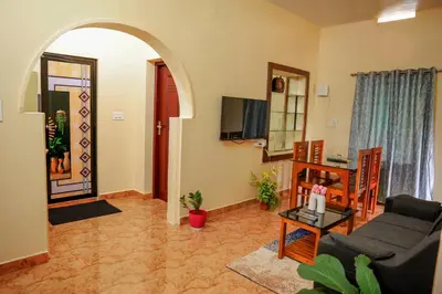 a living room with a couch and a table at Orange Villa -3 AC Rooms Near Airport in Ernakulam