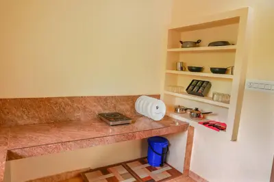 a kitchen with a counter top and shelves at Orange Villa -3 AC Rooms Near Airport in Ernakulam