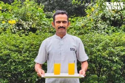 a man holding a tray with a glass of orange juice at StayVista at Hermitage 4BR - Boutique Stay - Relax in Nature in Irpu