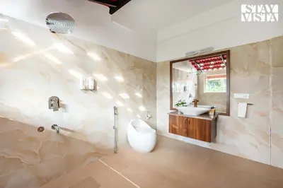 a bathroom with a sink and a toilet and a mirror at StayVista at Hermitage 4BR - Boutique Stay - Relax in Nature in Irpu