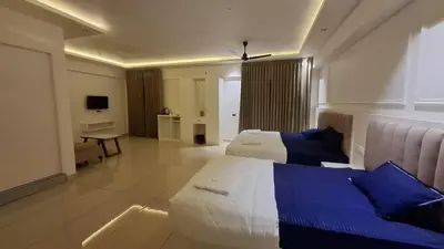 a large hotel room with two beds and a couch at Aagneyam Grand Resort in Kozhikode