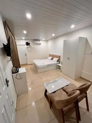 a small room with a bed and a table and chairs at Aagneyam Grand Resort in Kozhikode
