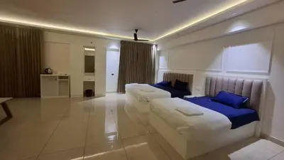 a hotel room with two beds and a couch at Aagneyam Grand Resort in Kozhikode