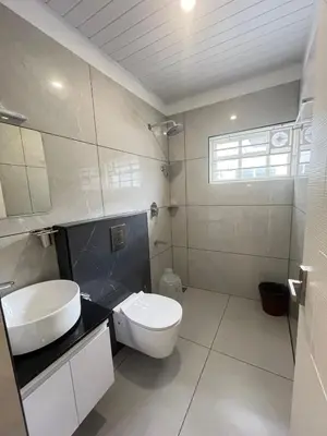 a bathroom with a white toilet and a sink at Aagneyam Grand Resort in Kozhikode