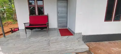 a red chair sitting on the porch of a house at Silent Stays in Kelakam