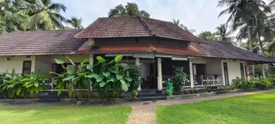 a house with a green lawn in front of it at BharathaPuzha Resort in Kārakkād