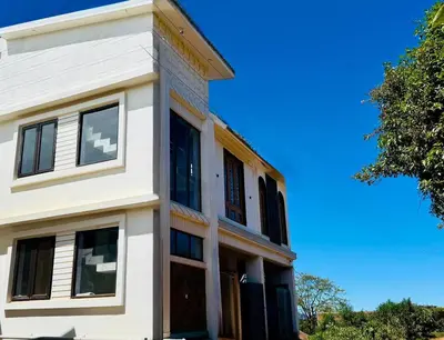 a white building with a blue sky in the background at Ever Fresh High View By Let's Inn in Ooty