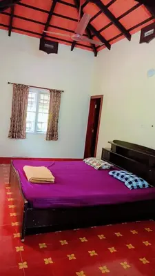 a bedroom with a purple bed in a room at Farm Retreat by TastyTek in Pollāchi
