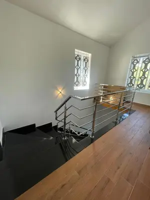 an empty room with a wooden floor and a staircase at IndivaStays - Moon Stone Villa in Ooty