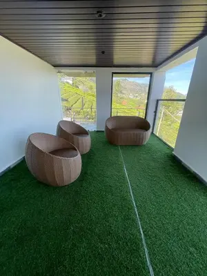 a room with two chairs and green carpet at IndivaStays - Moon Stone Villa in Ooty