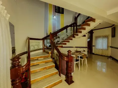a wooden staircase in a house with a rainbow at Upavan Villa-Two KM From Aluva Metro Station in Alwaye