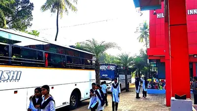 a group of people standing in front of a bus at Hill palace Inn in Periya