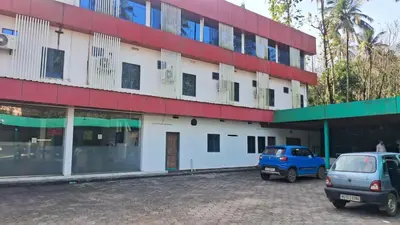 two cars parked in front of a building at Hill palace Inn in Periya
