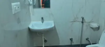 a white bathroom with a sink and a toilet at Hill palace Inn in Periya