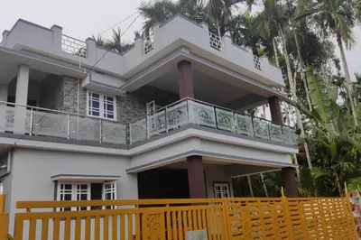 a house with a balcony on top of it at Maurya Homestay in Napoklu
