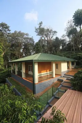 a small house with a green roof at Coffee Courtyard - Boutique Estate Retreat, Coorg in Kurchi