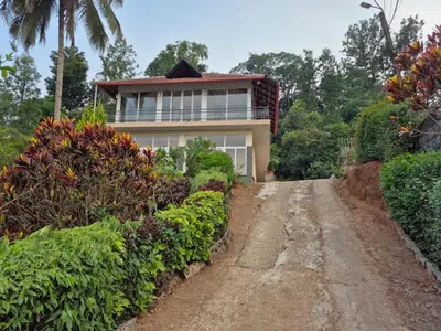 a house on the side of a dirt road at Nvoyages Plantataion Stay Coorg in Madikeri