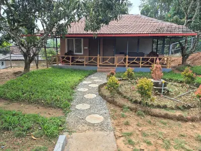 a house with a pathway leading to a yard at Nvoyages Plantataion Stay Coorg in Madikeri
