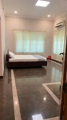 a large bed in a room with a window at Abida Mansion 4BHK Near MCP Convention Centre Irinjalakuda in Irinjālakuda