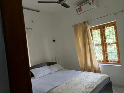a bedroom with a bed and a window at Aathira Agri Homes in Trichūr
