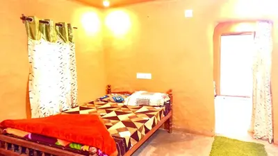 a bedroom with a bed and a window and a door at Mud bees resort in Kanthalloor