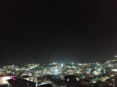 a view of a city lit up at night at Mithra Cottages Individual Room's with Balcony in Ooty