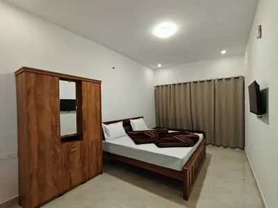a bedroom with a bed with a wooden frame and a mirror at Mithra Cottages Individual Room's with Balcony in Ooty